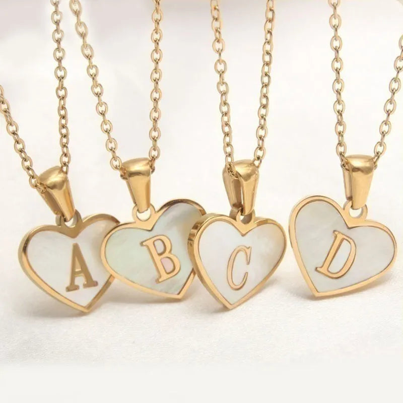 Gold plated heart pendant necklace with white shell centre on a stainless steel chain.