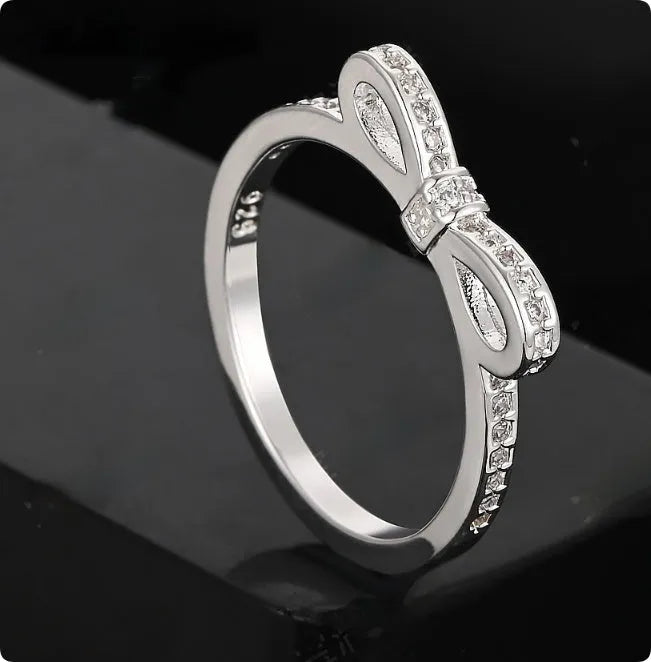 Silver-coloured bow design ring with sparkling rhinestone zircon crystal decoration.