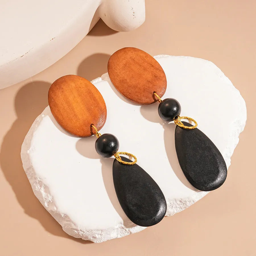 Brown-black wooden earrings with silver needle accents in elliptical European style design