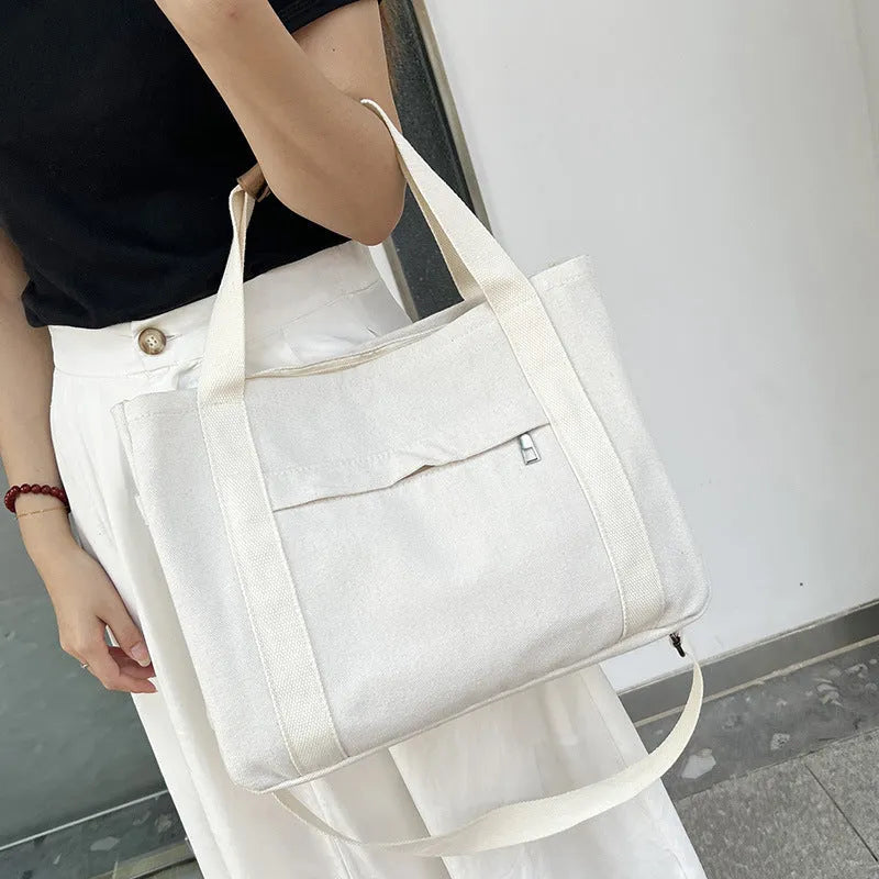 Large khaki canvas tote bag for women with open top showing internal laptop and camera pockets