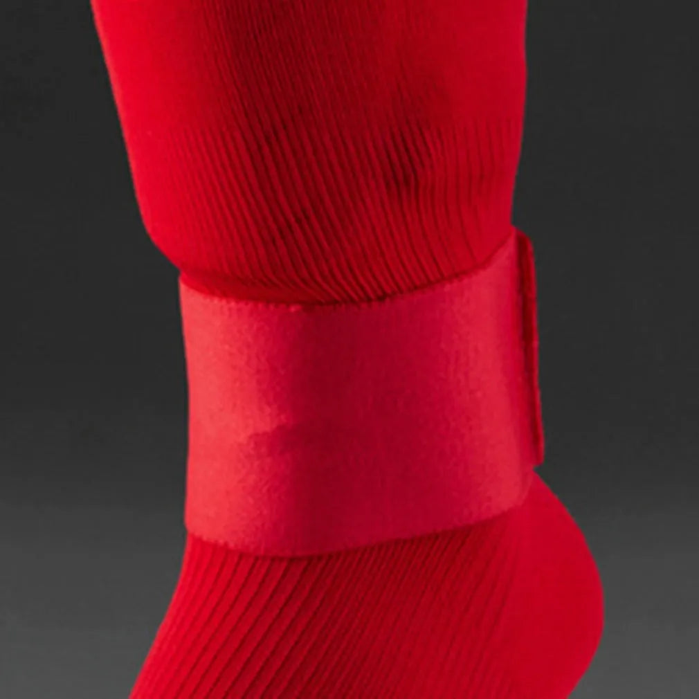 Rubber shin guard fixing strap in red, shown next to a football.