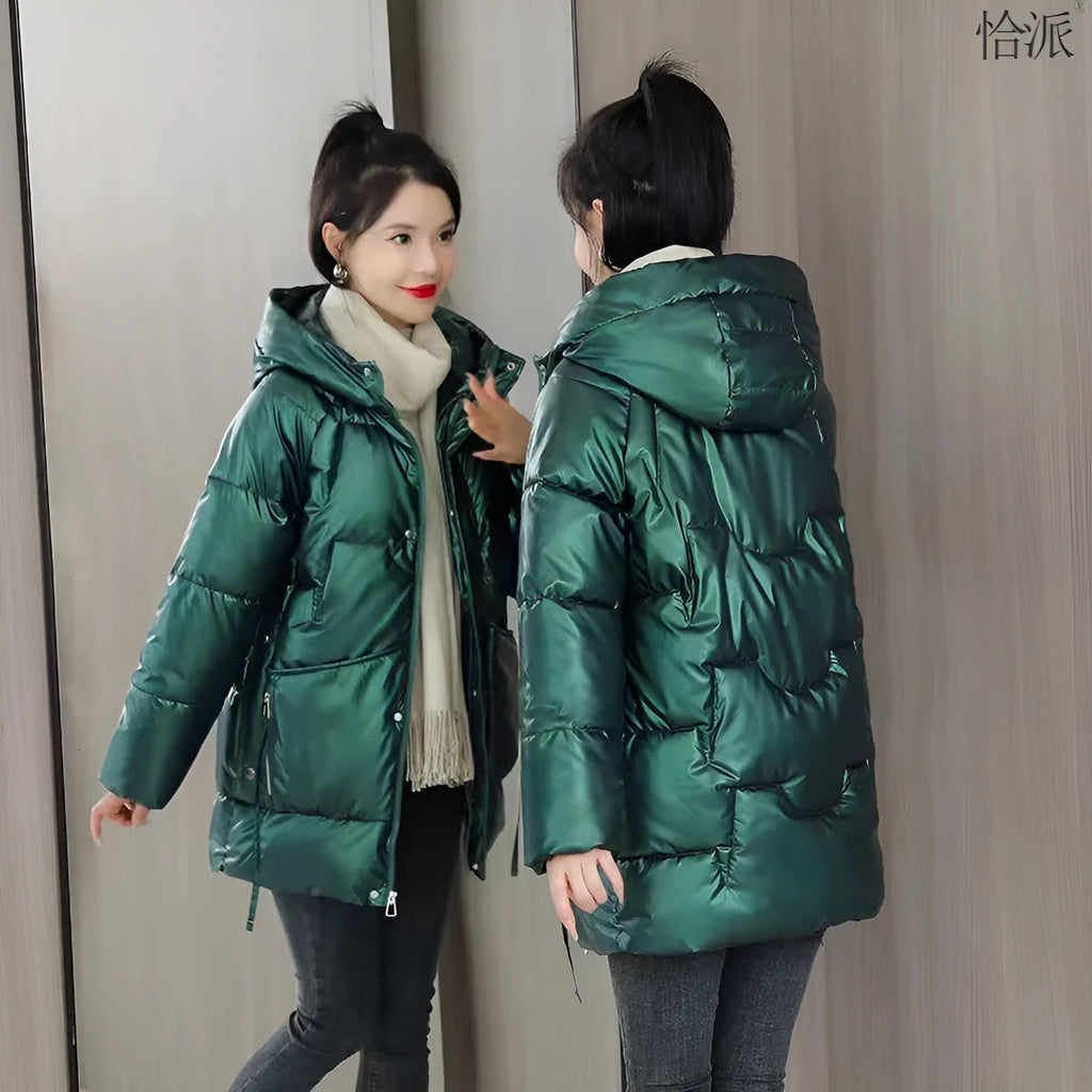 A green loose-fit hooded winter jacket for women on a hanger, showing long sleeves and thick insulation.