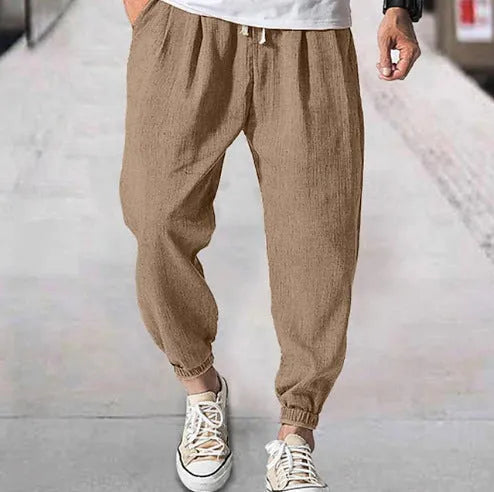 Men's loose casual cotton trousers with an elasticated ankle band in light green.
