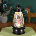 Portable crystal ball oil lamp Christmas ornament showing light-emitting snowman or elderly figure design on a desk.