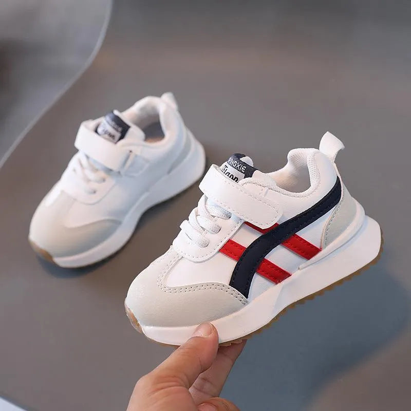 Children's white casual sneaker with Velcro strap on a non-slip rubber sole.