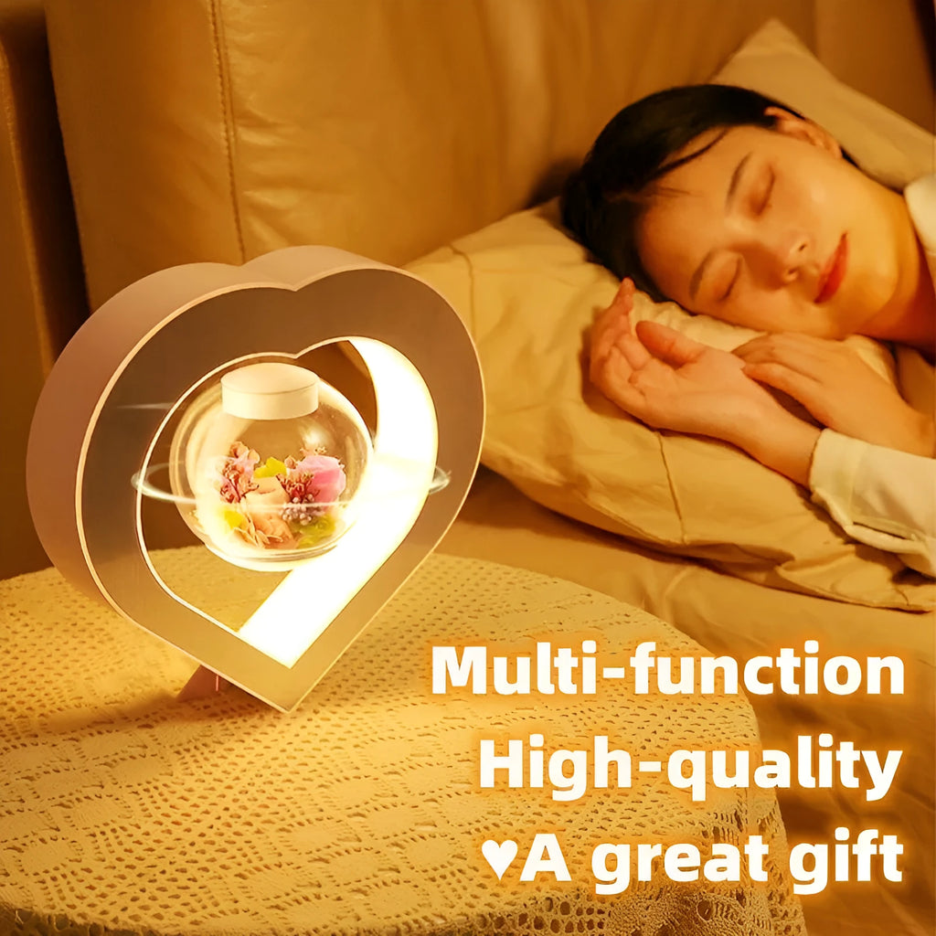 Floating heart LED night light with magnetic levitation displaying a red eternal flower on a desk