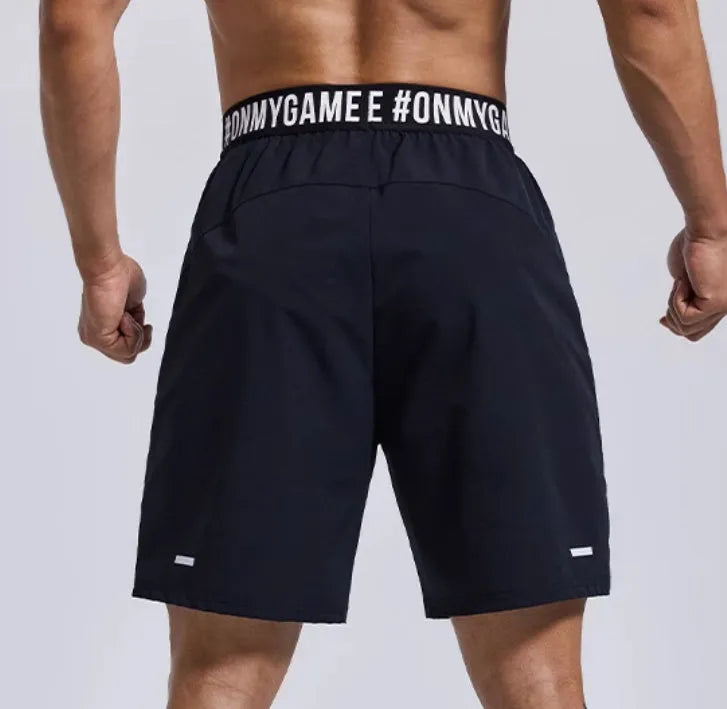 Men's loose grey athletic shorts with an elastic fly opening and letter print, shown from the front.