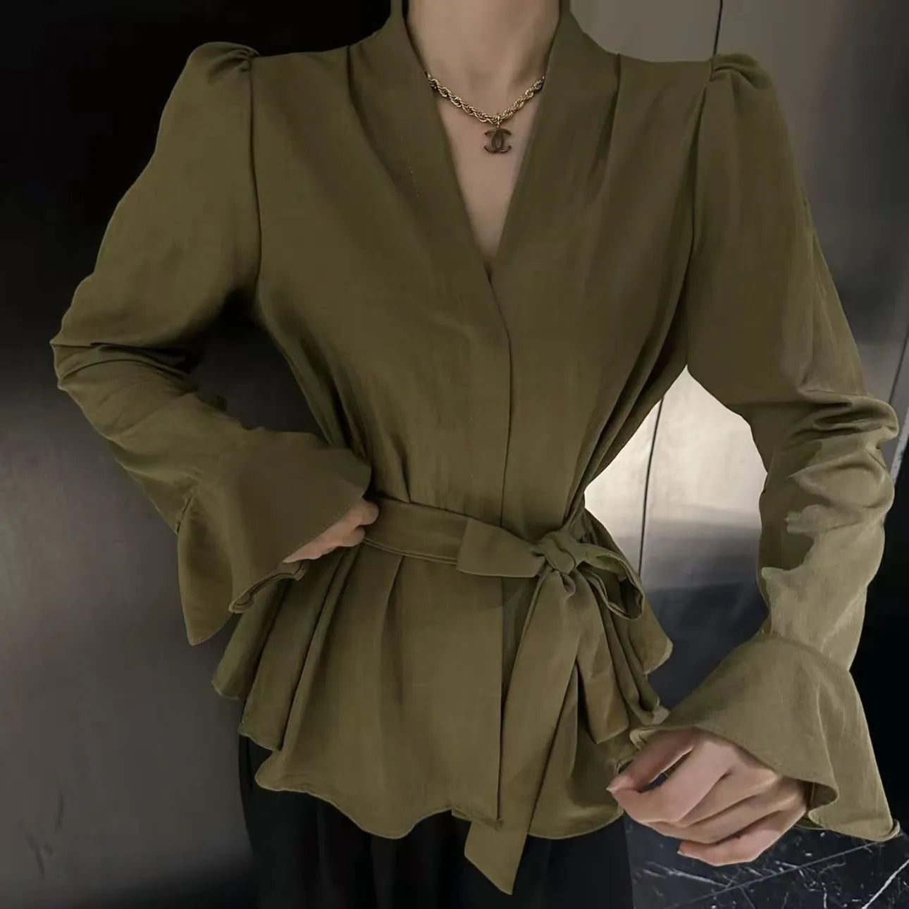Women's black French-style tied shirt with an irregular collar and long bell sleeves.