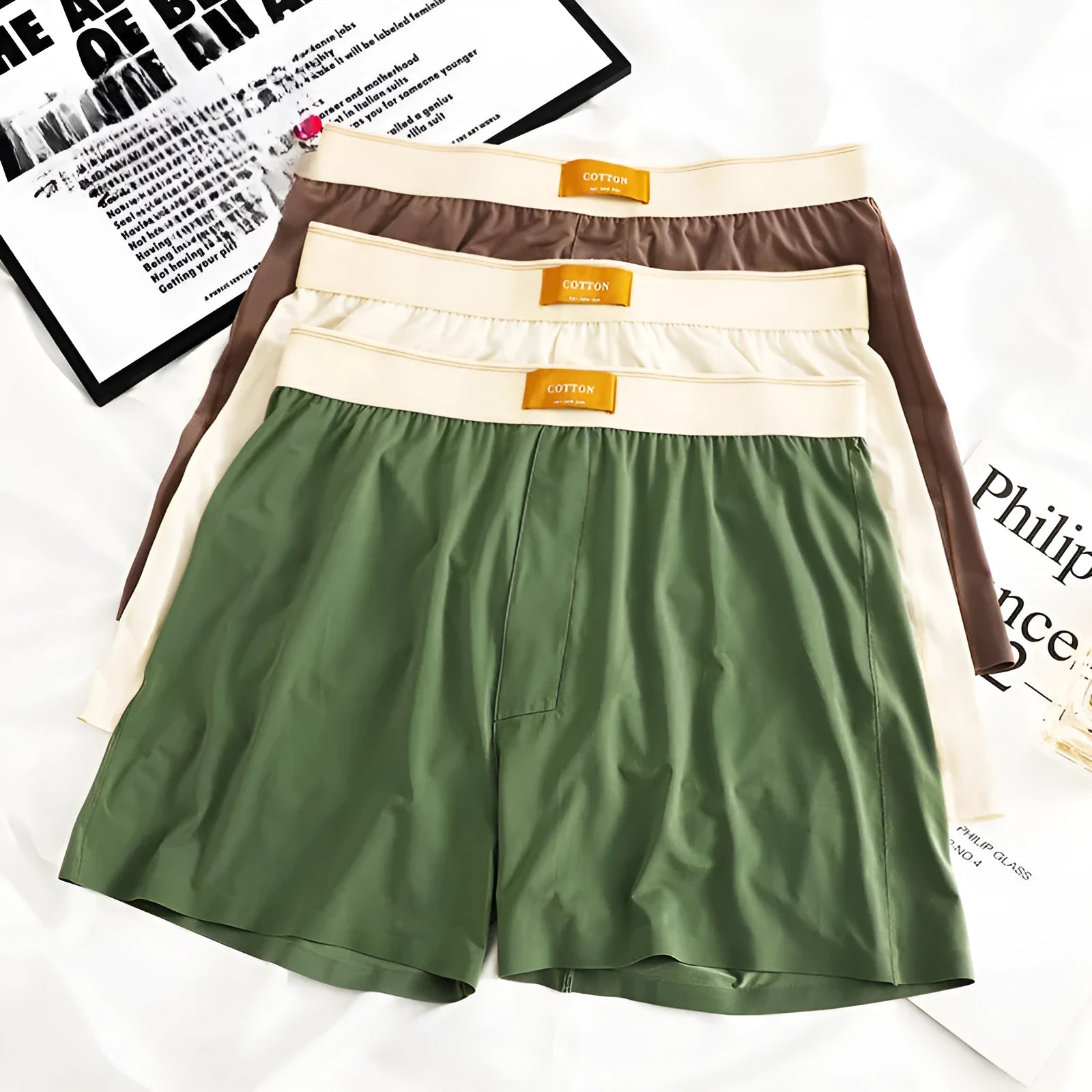 Pack of three men's solid colour loose fit ice silk underwear briefs on a grey background.