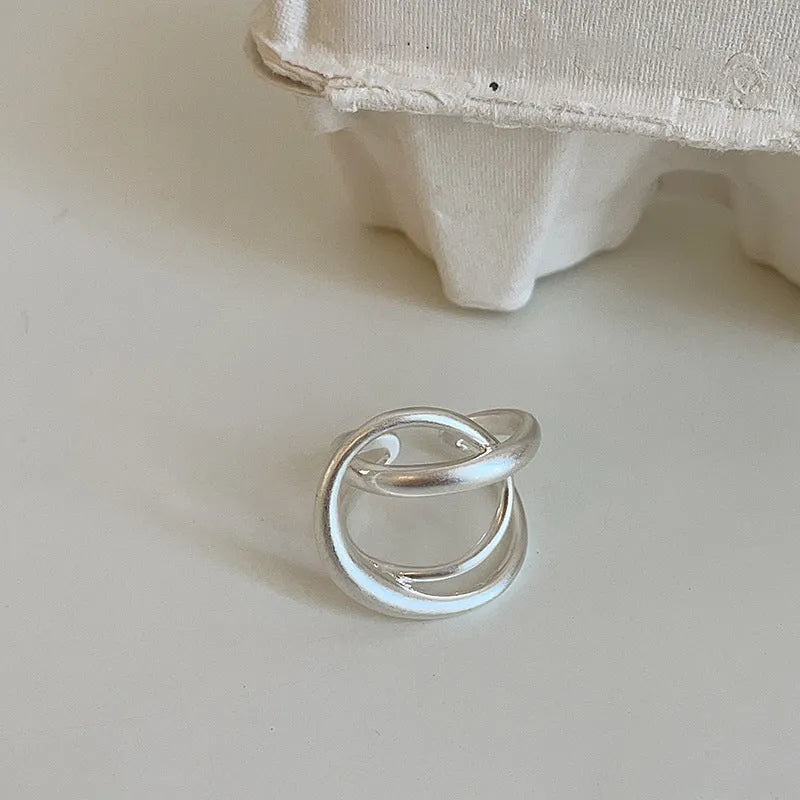 Geometric open ring with three-dimensional interlaced matte metal design in gold or silver electroplated finish