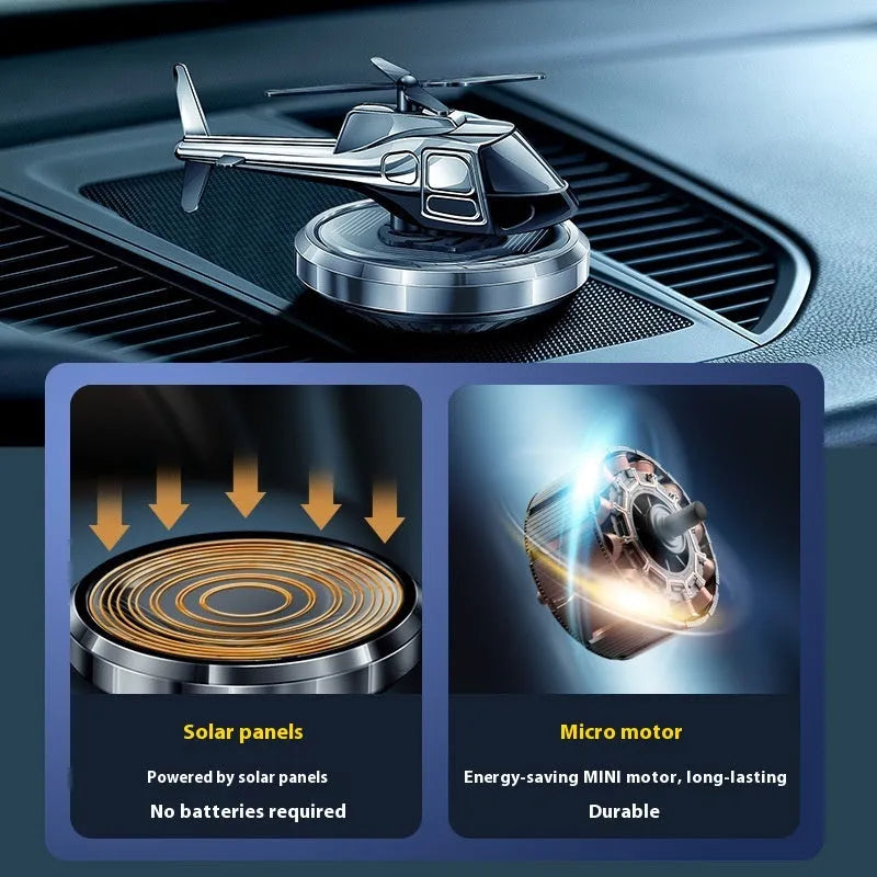 Silver metal solar-powered rotating helicopter car perfume ornament on dashboard