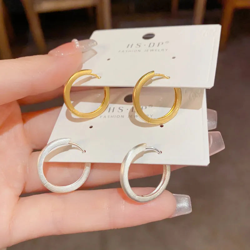 Women's geometric ear clips with round eyelet design in gold plating on copper