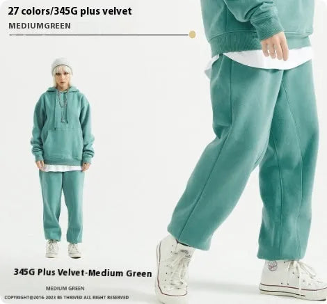 Man wearing dark brown velvet sweatpants with an ankle band and elastic waist.