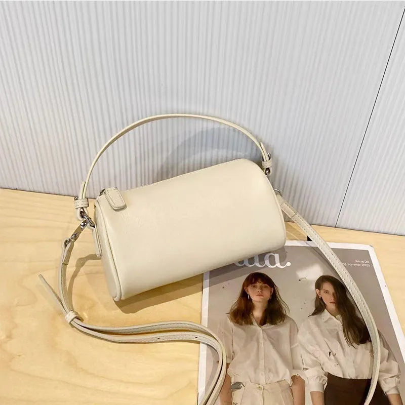 Soft genuine leather cylindrical crossbody bag in street style, shown in black, with a single strap.
