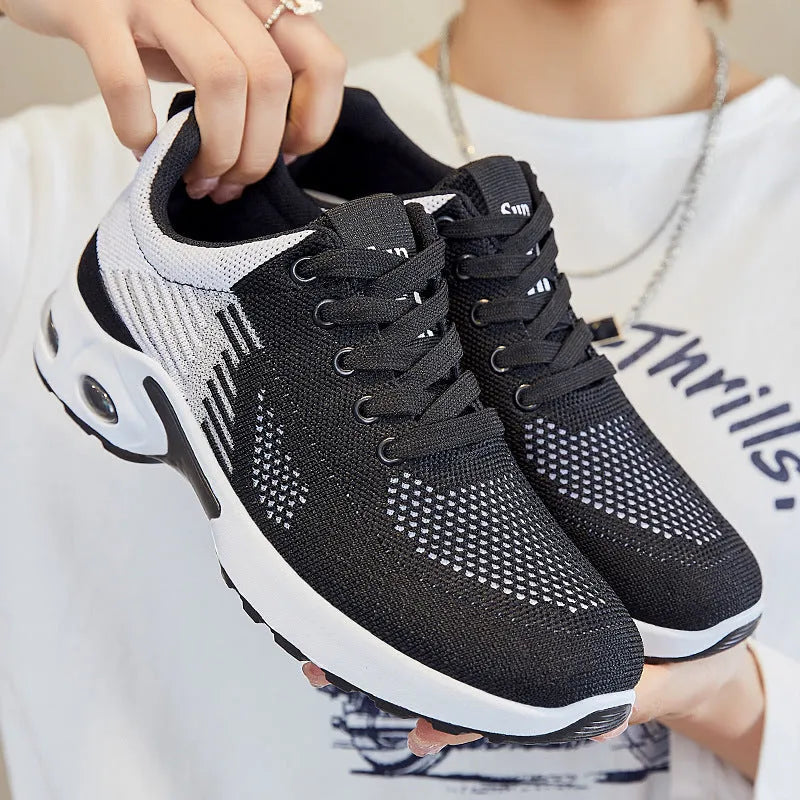 Women's Flyknit casual running shoes in striped pattern with lace-up front, shown in pink colour.