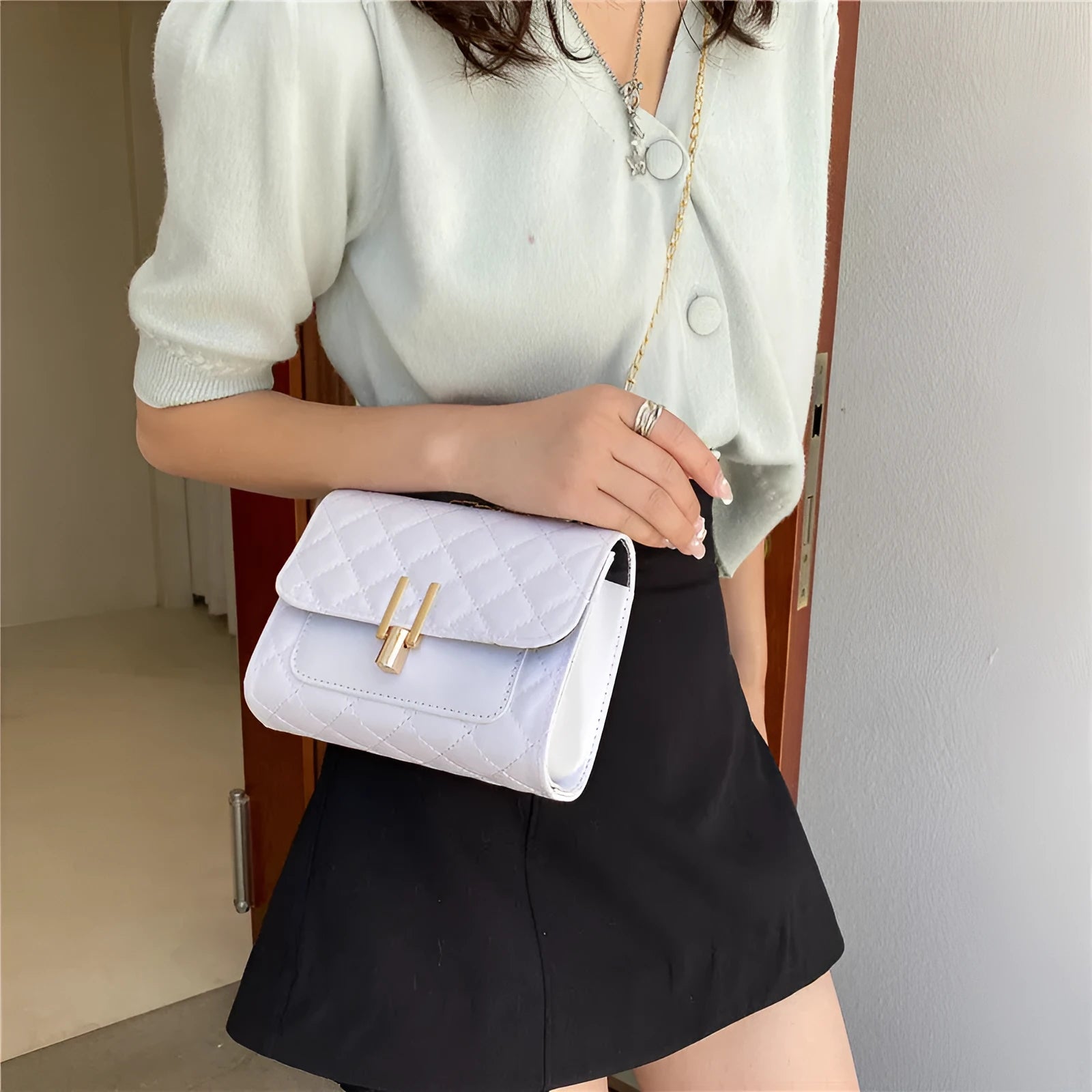 Women's crossbody bag with diamond lattice chain detailing and adjustable shoulder strap