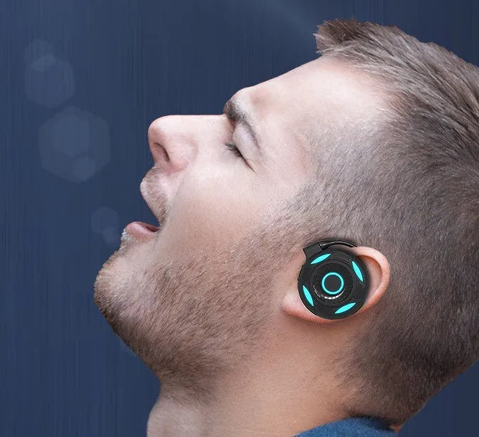 Black Bluetooth gaming earphones with hanging ear design showing USB charging port