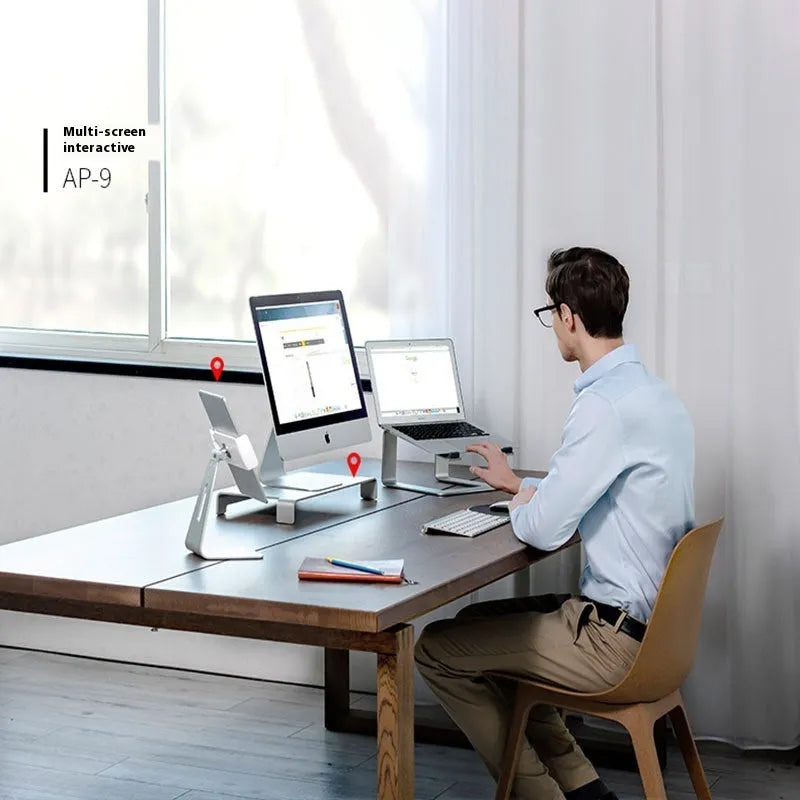 Black aluminium alloy laptop stand on a desk, elevating a silver laptop.