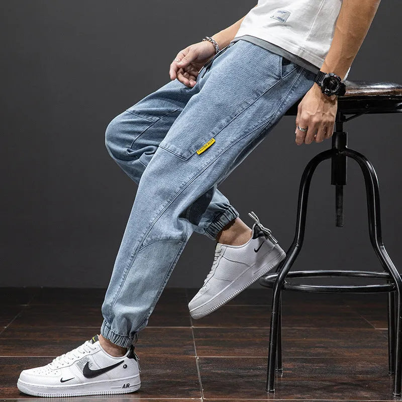 Man wearing loose fit blue cargo jeans with a straight leg and skinny ankle opening.