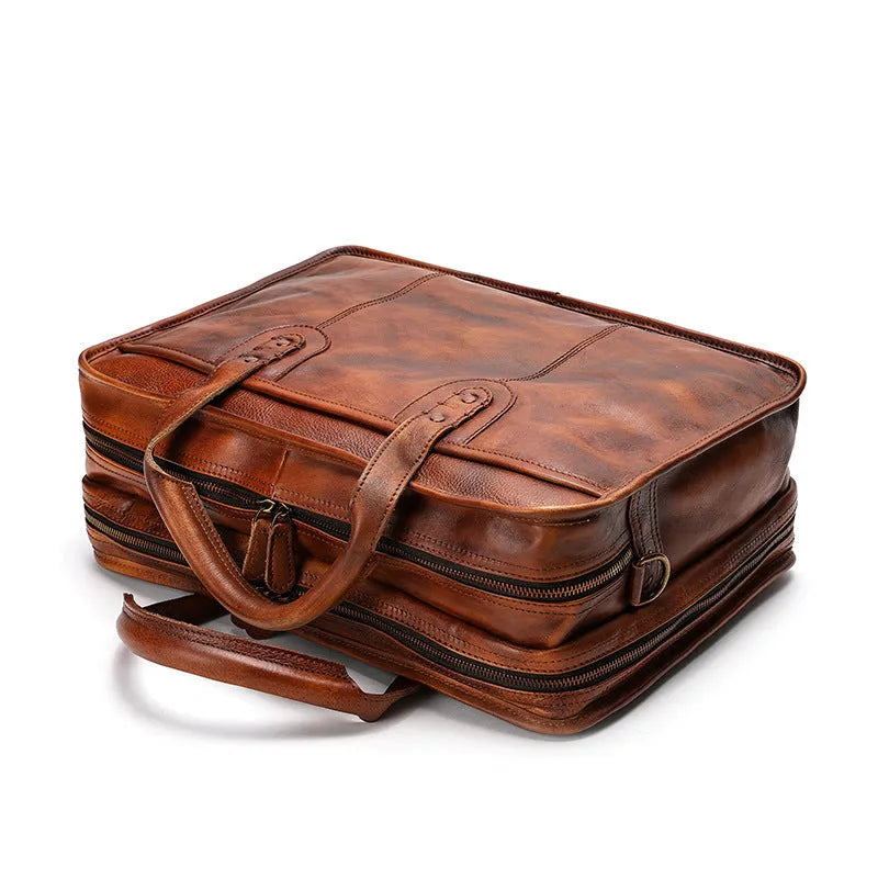 Vintage brown leather men's briefcase open showing internal laptop pocket and document organisers