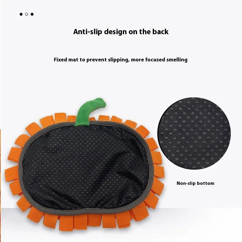 Orange pumpkin-shaped pet slow feeder mat on floor with scattered kibble
