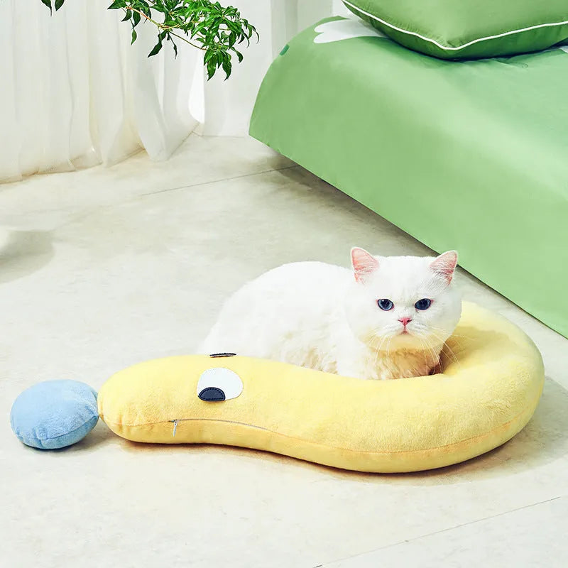 A rectangular blue pet sleeping pillow on a floor, shown next to a small dog for scale.