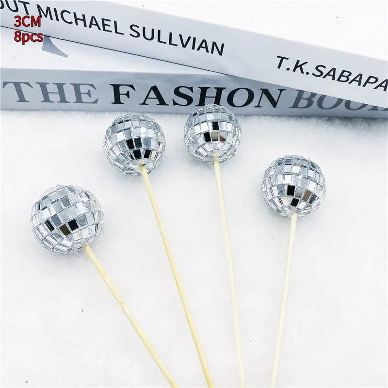 Glass disco ball cake decoration on a wooden stick, shown in different sizes.