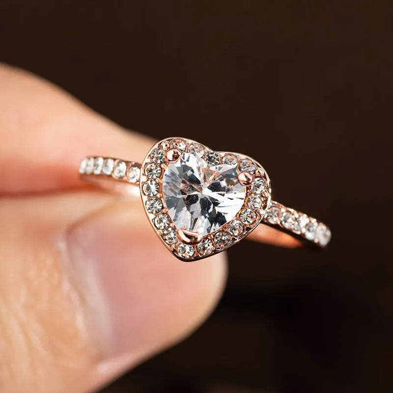 Heart-shaped women's ring with crystal decoration in rose gold or silvery finish on a size chart.