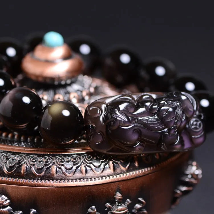 Polished natural crystal Pi Xiu bracelet with geometric beads on a wrist.