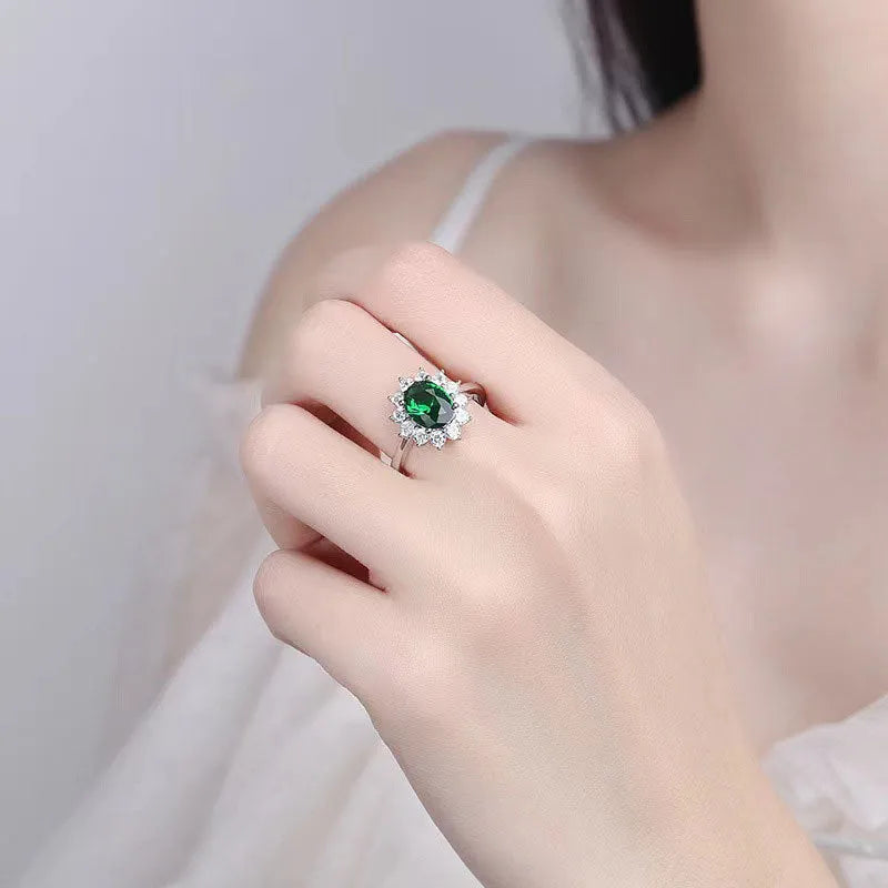 Copper women's ring with floral zirconium design in green, blue, or red on a model's hand.