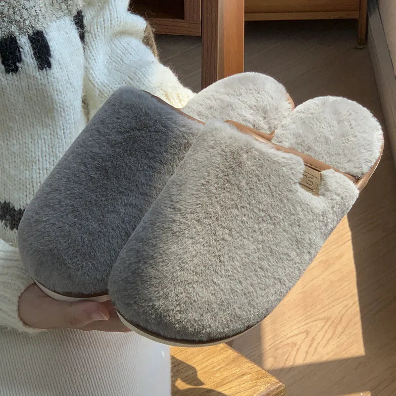 A pair of solid colour plush winter slippers with a non-slip PVC sole and car stitching detail.