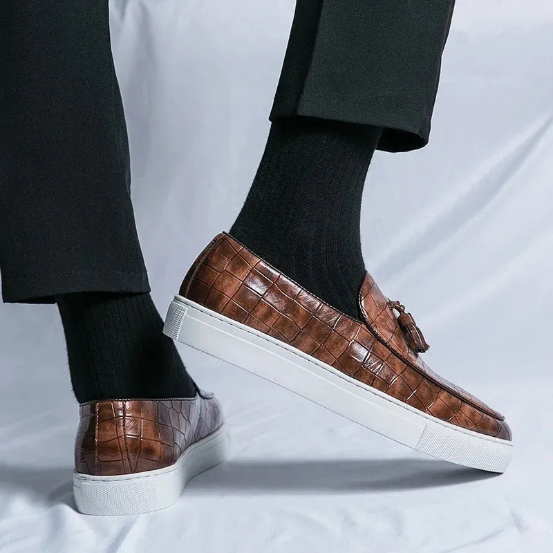 Men's black faux leather sneakers with a tassel detail on the upper, shown on a white background.