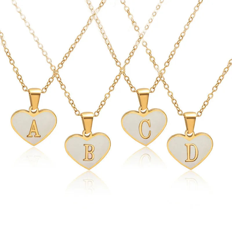 Gold plated heart pendant necklace with white shell centre on a stainless steel chain.