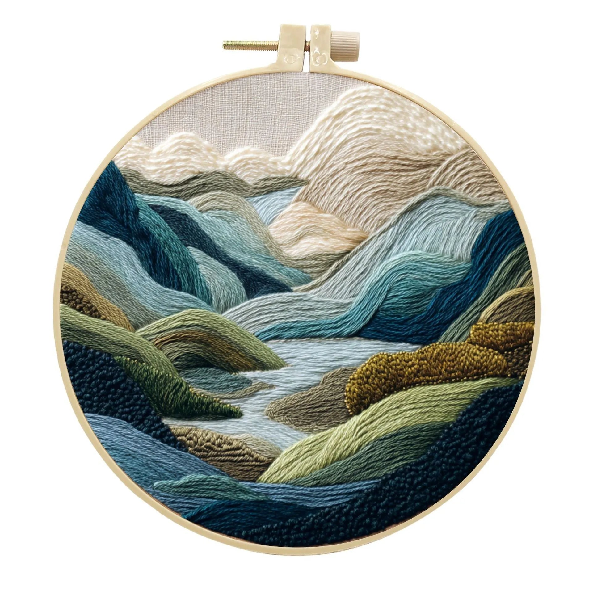 DIY embroidery kit with landscape-printed cotton fabric, embroidery hoop, needles, and coloured thread spools.