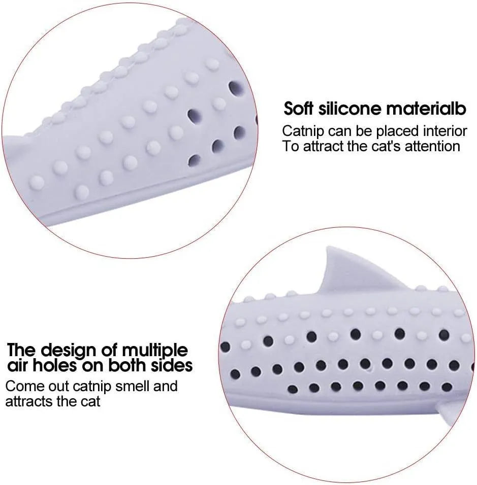 Green silicone fish-shaped cat chew toy with breathable side holes on wooden floor