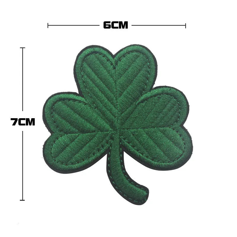 Outdoor embroidered fabric badge with Velcro strip backing on a green clover design.