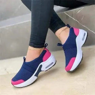 Women's flat sneakers in light grey with mesh upper, round toe, and rubber sole.
