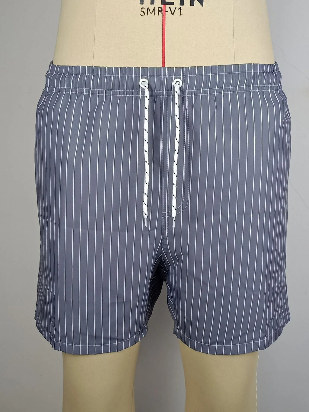 Men's striped beach shorts in polyester blend fabric, showing straight leg opening and available colour options.