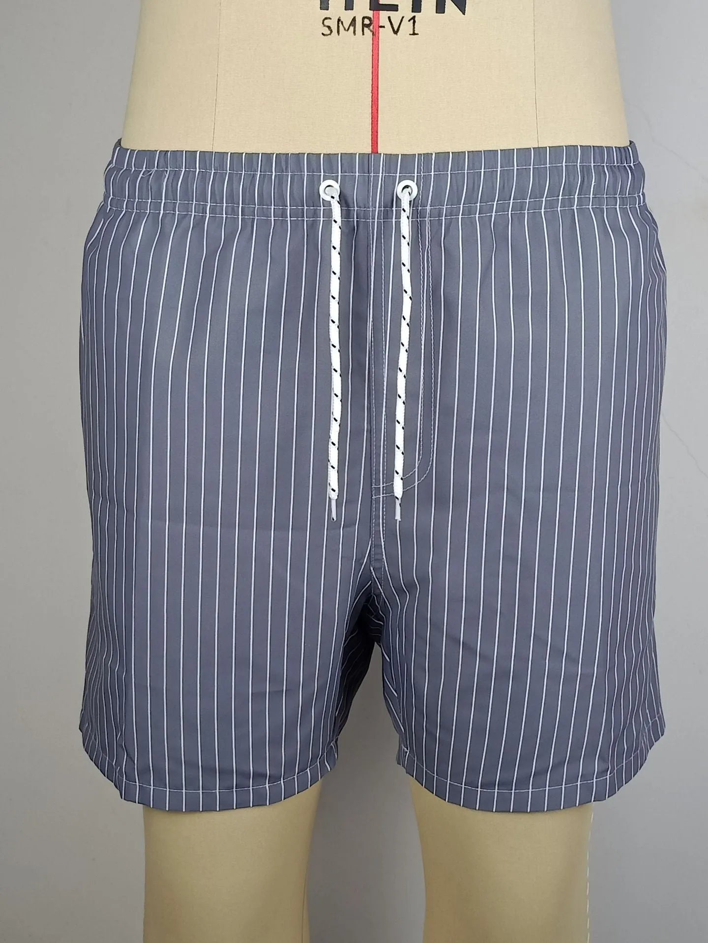 Men's striped beach shorts in polyester blend fabric, showing straight leg opening and available colour options.