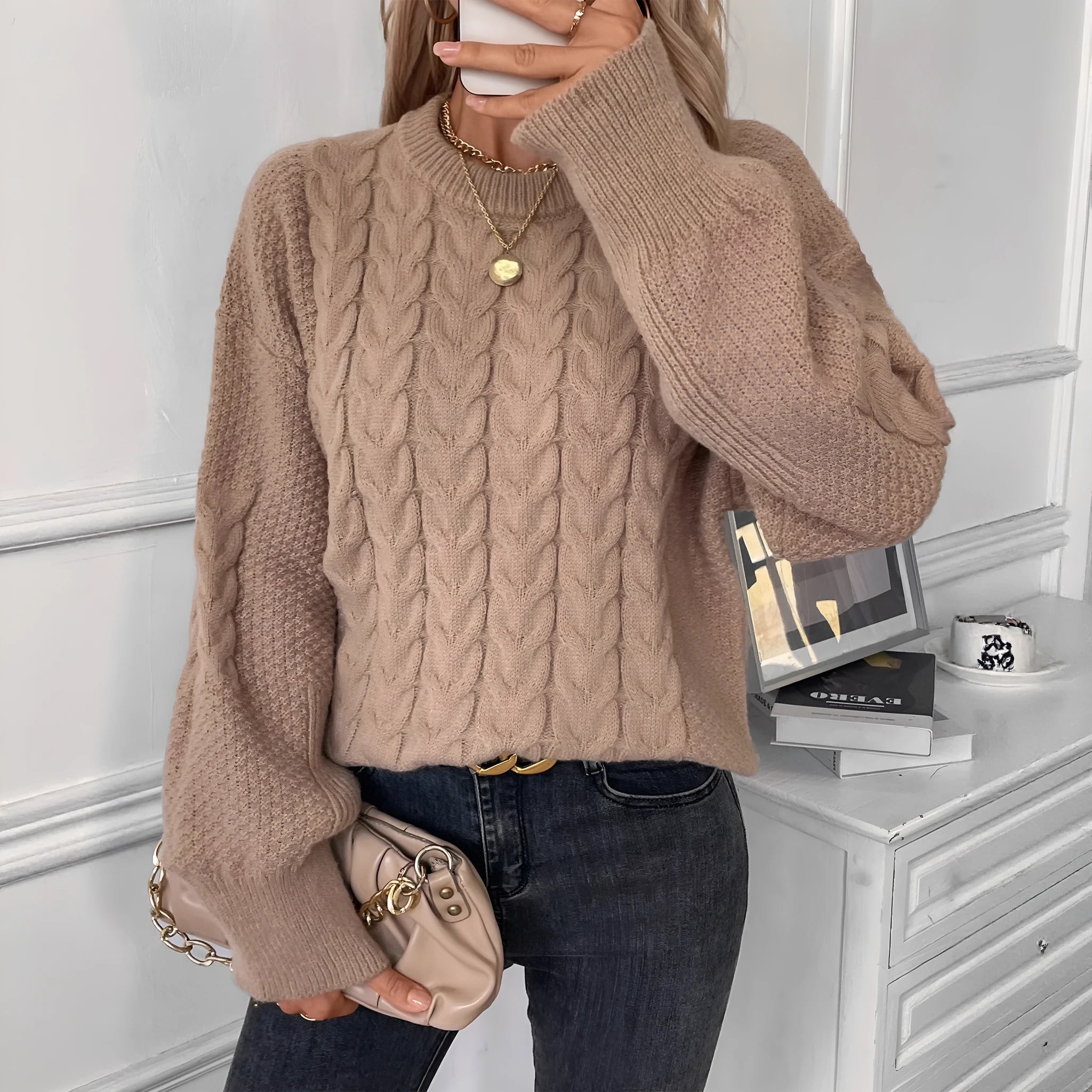 Women's loose beige casual sweater with round neck and twist detail on a hanger.