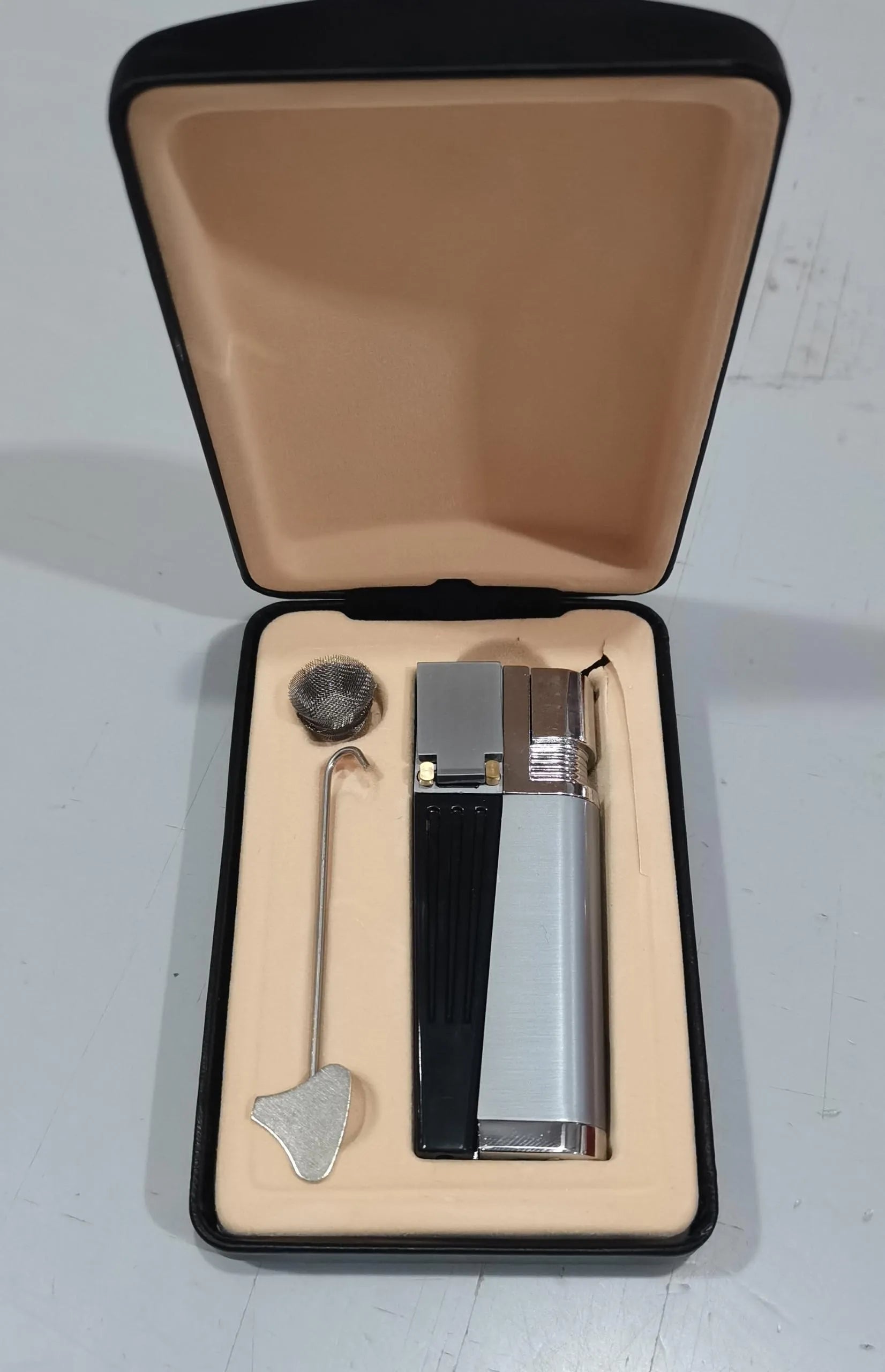 Silver and black foldable metal pipe lighter with stash compartment closed.