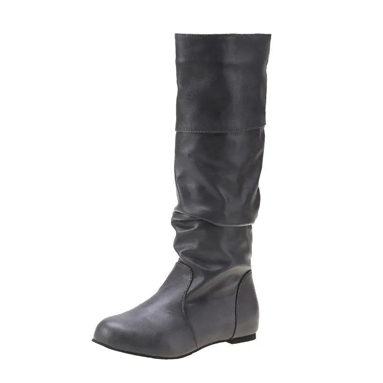 Women's flat slip-on long boots with round toe in black, shown on a foot.