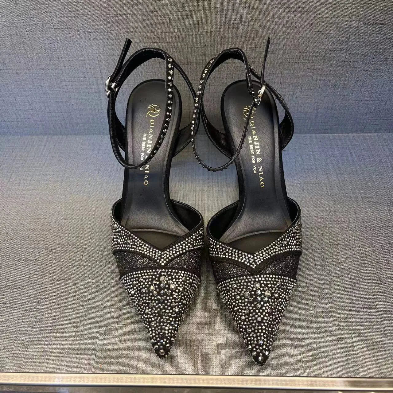 Women's black hollow high heels with red sole and pointed toe on a stiletto heel