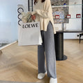 Women's cream white thick knitted wide-leg trousers with a high waist and drooping hem laid flat.