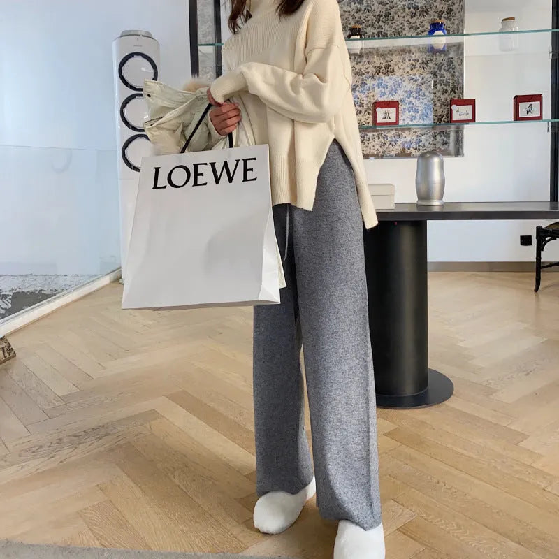 Women's cream white thick knitted wide-leg trousers with a high waist and drooping hem laid flat.