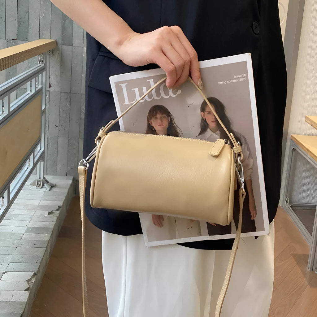 Soft genuine leather cylindrical crossbody bag in street style, shown in black, with a single strap.