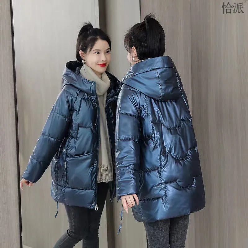 A green loose-fit hooded winter jacket for women on a hanger, showing long sleeves and thick insulation.