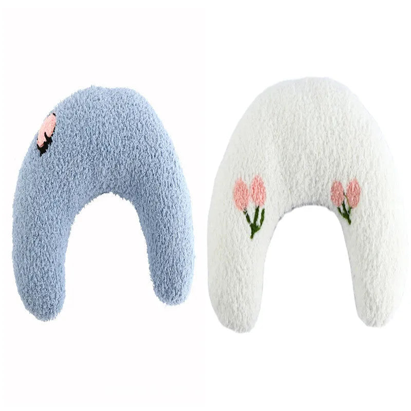 Small white U-shaped plush pet pillow for cats and small dogs on a neutral background.