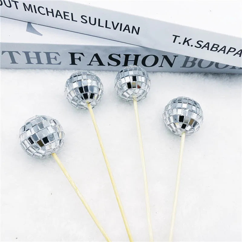 Glass disco ball cake decoration on a wooden stick, shown in different sizes.