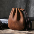 Vintage cowhide drawstring bundle wallet in genuine leather showing retro style and sewing thread detail.